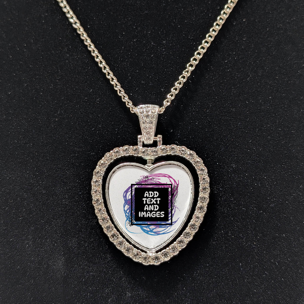 Customizable double-sided heart shaped silver rhinestone pendant with a silver necklace on a black stand