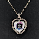 Customizable double-sided heart shaped silver rhinestone pendant with a silver necklace on a black stand