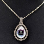 Customizable double-sided teardrop shaped silver rhinestone pendant with a silver necklace on a black stand