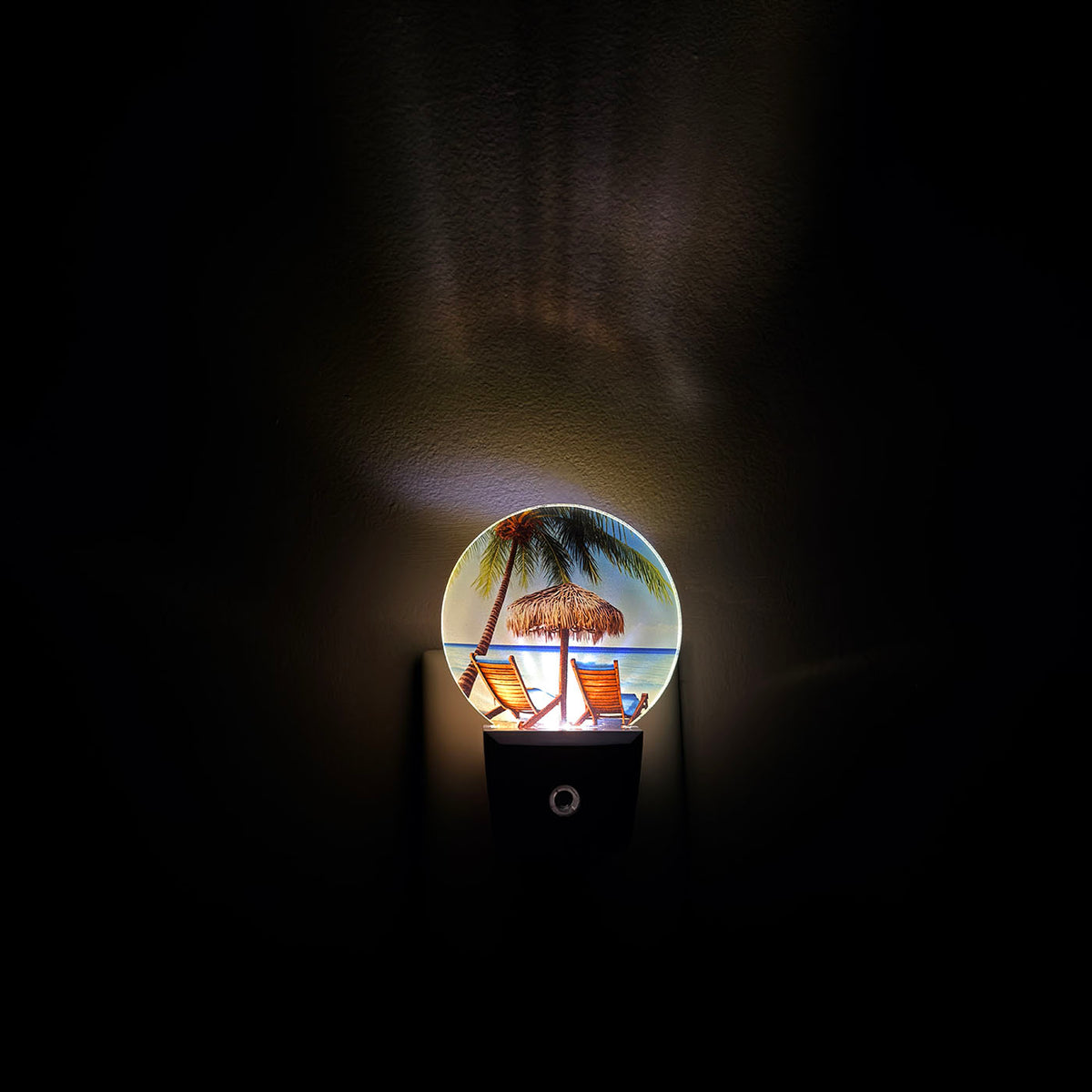 Decorative night light with a beach scene design on a dark background