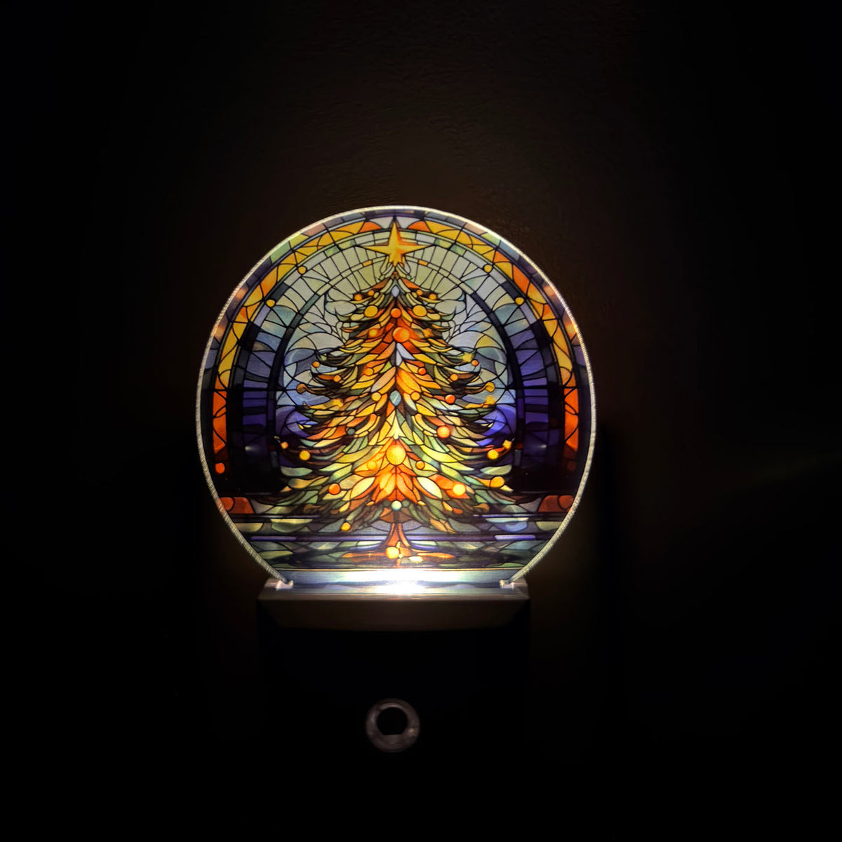 Decorative night light with stained glass design of a Christmas tree on a black background