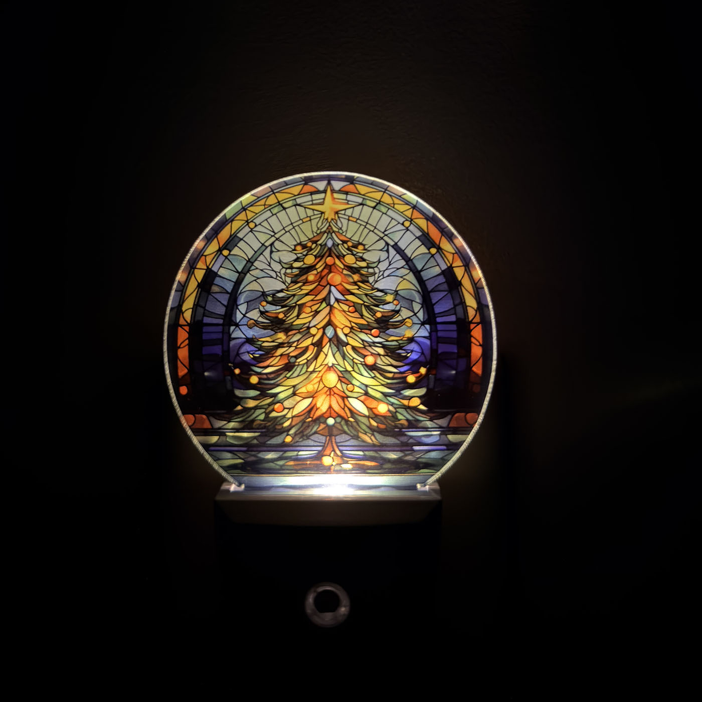 Decorative night light with stained glass design of a Christmas tree on a black background